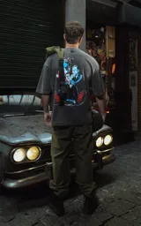 Remera negra con efecto nevado/acid wash, corte oversize, con estampado gráfico en la espalda inspirado en la película 'Bastardos sin gloria' de Tarantino, mostrando personajes con armas y dinamitas.