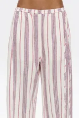 Pantalón de corte jogger con largo tobillero y cintura ajustable con cordón. Diseño a rayas verticales rojas y blancas.