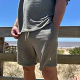 Short de tejido color blanco con logo bordado en negro en la pierna izquierda.