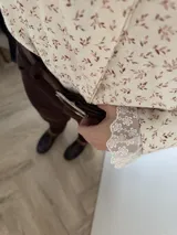 Camisa color crema con estampado de hojas en color vino, cuello babero y puños con puntilla de tul bordado en algodón.