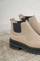 Botas Chelsea de cuero color marrón con paneles laterales elásticos negros y suela track de goma negra.