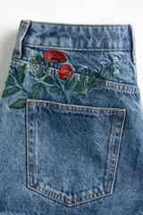 Short de jean de tiro alto con bordados de flores rojas, amarillas y blancas.