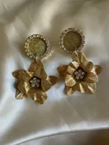 Par de aros colgantes con base circular negra con borde de strass y dije de flor negra con centro de strass.