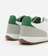 Championes deportivos de cuero color blanco con detalles en gris y verde.