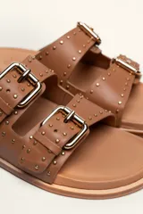 Sandalias marrones de cuero vacuno con doble tira y hebillas metálicas ajustables.