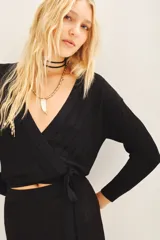 Cardigan crop negro tejido en punto desagujado con lurex, escote V cruzado y ajuste en la cintura.