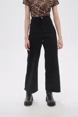 Pantalón negro de jean de corte ancho con cintura alta y ruedo desflecado.