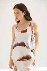Musculosa blanca con estampado abstracto en tonos marrones y celestes, con cuello redondo y sisas con ribete en color crudo.