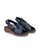 Sandalias color beige con tiras cruzadas en la capellada, una tira color dorado y otra color beige. Tiene una tira trasera con hebilla para ajustar al tobillo y suela baja.