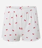 Conjunto de pijama short doll blanco con estampado de cerezas rojas, confeccionado en tejido rib. Incluye musculosa con puño y short con cintura elástica y bajo frufru.