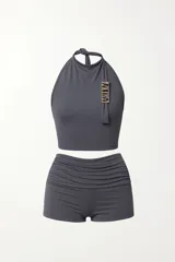 Conjunto deportivo gris compuesto por un top halter con logo dorado y un short con cintura fruncida.