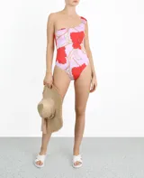 Traje de baño entero de lycra color lila con estampado de flores rojas, con un solo tirante ancho y escote asimétrico.