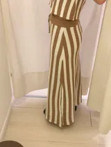 Pollera larga de punto color beige con rayas verticales marrones, corte recto y cintura con cordón ajustable.