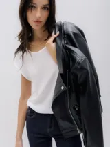 Chaqueta biker negra de cuero sintético con cierre asimétrico, cuello con solapas y tachas plateadas.