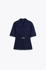 Chaqueta azul marino de punto con cuello solapa y manga corta. Incluye cinturón fino con hebilla dorada y cierre frontal con botones a tono.