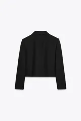 Chaqueta corta negra de tweed con cuello solapa, manga larga, bolsillos frontales con solapa y cierre frontal con botones plateados.