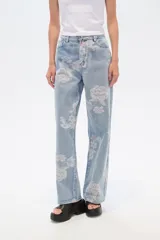 Pantalón de jean celeste con estampado de flores rosas, corte recto y tiro medio.