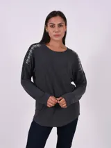 Blusa gris oscuro de manga larga con detalle de pespuntes blancos en los hombros.