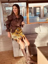 Minifalda con estampado geométrico en tonos amarillo, negro y gris, con detalle de plumas en el ruedo.