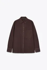 Camisa marrón de algodón con cuello solapa, manga larga con puños abotonados, bolsillo de parche en el pecho y cierre frontal con botones.