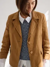 Blazer color mostaza de lino con corte estructurado, solapas con pespuntes y bolsillos con solapa.