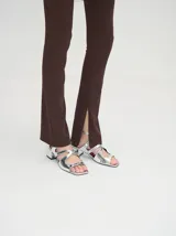 Sandalias plateadas de cuero charol con tiras cruzadas y taco cuadrado bajo.