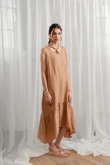 Vestido midi color camel de lino, con breteles anchos, cuello redondo y corte holgado con frunces.