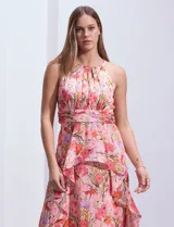 Vestido largo de gasa estampada con flores, escote halter, busto plisado, corte en la cintura con faja plisada, falda delantera con sobrecapa y abertura central en la espalda con cierre invisible.