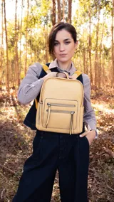Mochila verde con apertura superior y dos bolsillos frontales con cierres metálicos. Tiene bolsillos laterales, tres bolsillos internos, correa larga regulable y correas traseras regulables.