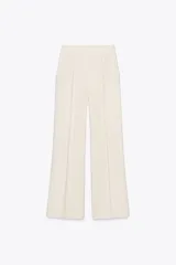 Pantalón palazzo color crema, de tiro alto, con bolsillos laterales y nervio marcado en el frente.