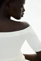 Top blanco de punto acanalado con escote off-the-shoulder, mangas cortas y corte ceñido.