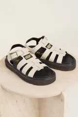 Sandalias de cuero sintético color lila con plataforma negra y tiras anchas cruzadas.