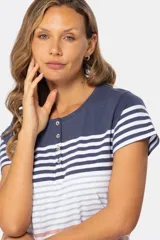 Remera de algodón con poliéster a rayas horizontales en azul, blanco, gris y rosa. Tiene cuello redondo, mangas cortas y botones personalizados en el escote.