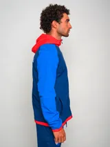 Campera deportiva con capucha, azul con mangas celestes y detalles en rojo. Escudo del Club Nacional de Football bordado en el pecho.