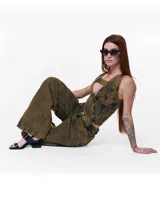 Pantalón unisex de denim 100% algodón con acabado marmolado color bronce. De tiro medio y calce wide/relajado, con pierna muy amplia y caída larga. Cintura con elásticos laterales, costuras curvas y bolsillos delanteros y traseros con bocas redondeadas.