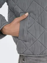 Campera corta acolchada color gris, con cuello alto, cierre frontal con cremallera y bolsillos laterales.