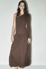 Vestido midi marrón de escote asimétrico con un hombro descubierto y una manga larga. La falda es amplia con bolsillos laterales y bajo tipo globo.