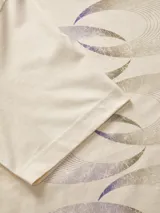 Remera color crema de algodón con cuello redondo y mangas cortas. Estampado en la espalda con diseño abstracto de círculos entrelazados y logo de la marca.