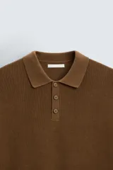Polo marrón de corte relaxed fit, tejido en punto de algodón. Tiene cuello solapa con cierre frontal de botonadura, manga larga y acabados en rib.