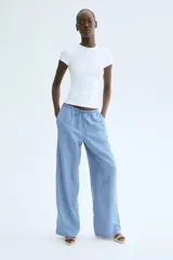 Pantalón de corte recto y holgado en tejido de mezcla de lino color celeste. Cuenta con cintura elástica con cordón de ajuste, bolsillos laterales y bolsillos traseros insertados.