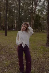 Camisa blanca de mangas largas con cuello clásico y cierre frontal con botones.