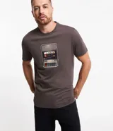 Remera gris de algodón con cuello redondo y mangas cortas. Presenta un estampado frontal de un reproductor de casete con la leyenda "To Travel".