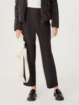 Pantalón negro de corte carrot, con cintura alta y bolsillos laterales.