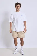 Remera blanca de corte holgado con pequeño estampado en el pecho.