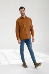 Camisa marrón de pana con cuello clásico, manga larga y cierre frontal con botones.