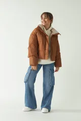 Campera puffer color marrón con cuello alto, corte cropped a la cadera, cierre metálico y botones.