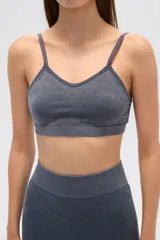 Top deportivo gris con breteles finos, corte al cuerpo y cuello en V.