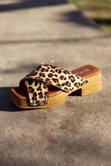 Sandalias de madera con plataforma y taco bajo, con tira ancha de cuero con estampado animal print y apliques de tachas plateadas.