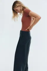 Body de manga corta color terracota, con escote redondo y corte alto en la entrepierna.