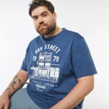 Remera azul de manga corta con estampa frontal de un edificio y texto en blanco.